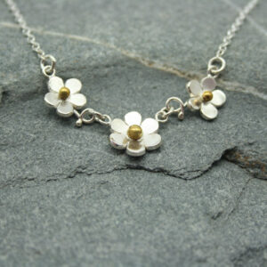 Silver three flower necklace with brass detail